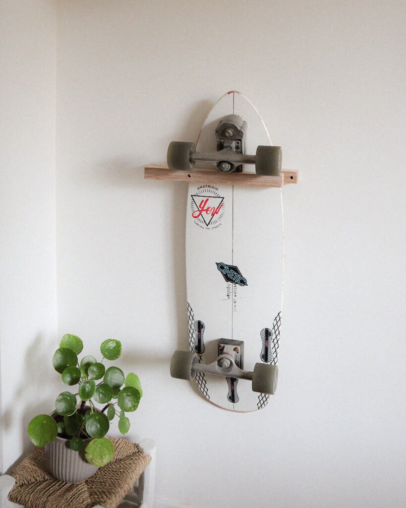Rack de skate mural vertical avec un surfskate installé. il s'agit du support simple.